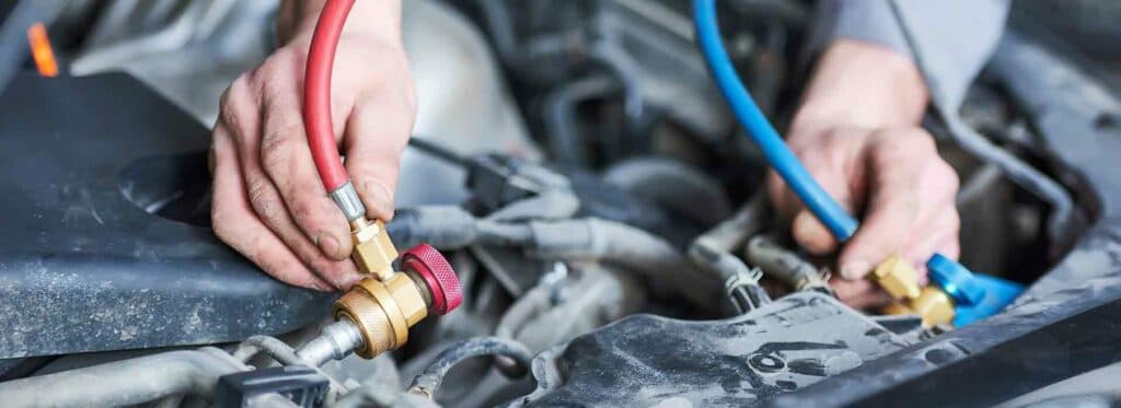 Teknisi Jakarta Intl Denso sedang memperbaiki AC mobil